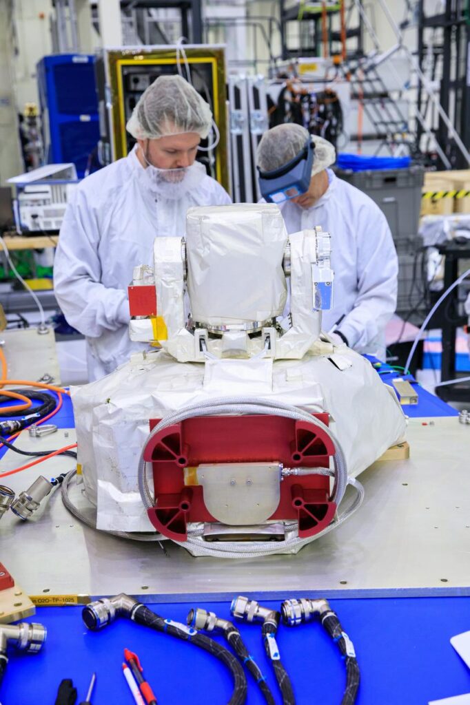 Inside the high bay of the Neil Armstrong Operations and Checkout Building at NASA’s Kennedy Space Center in Florida, technicians assemble on the Optical Communications System for the Artemis II mission on June 2, 2023. High-speed optical communications technology will allow astronauts to send and receive ultra-high-definition video from the surface of the Moon or other planets such as Mars.